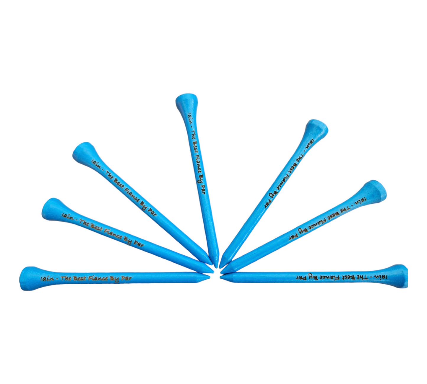 7 blue 83mm golf tees arranged in a fan shape with the text "Iain - The Best Fiance By Par" laser engraved into them