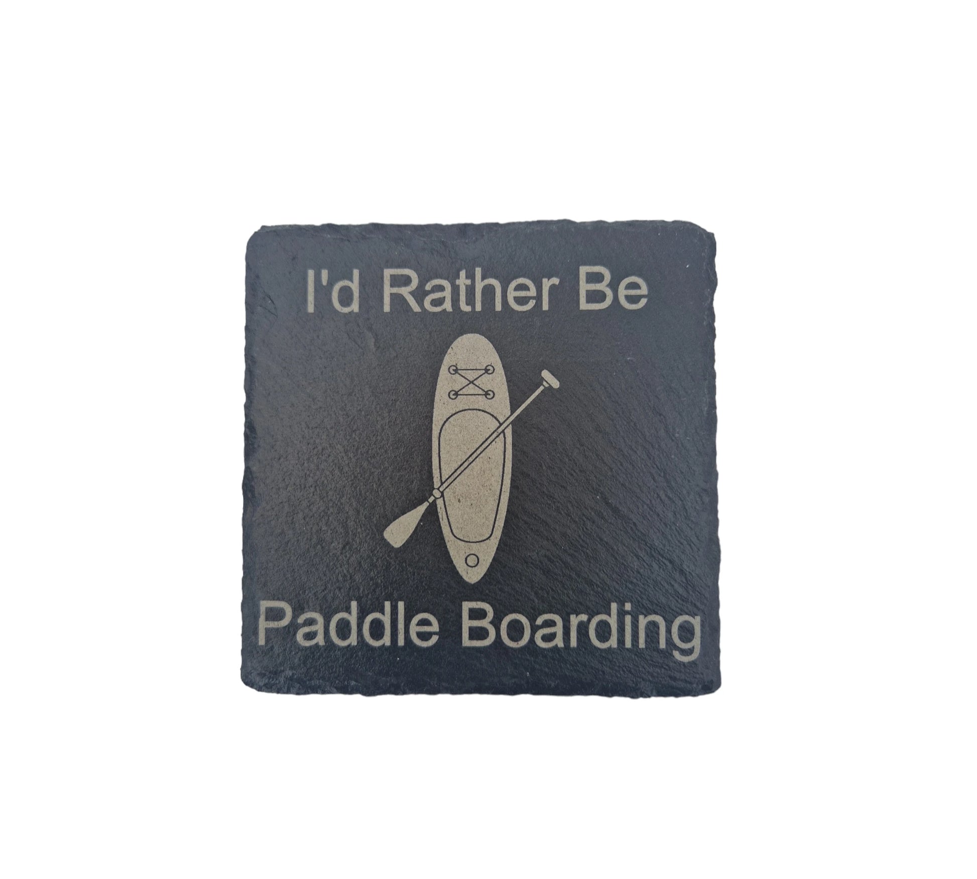 a black slate coaster with the text "I'd Rather Be" at the top of the coaster and "Paddle Boarding" at the bottom of the coaster. In the centre is the image of a paddle board with a paddle placed diagonally across it. 