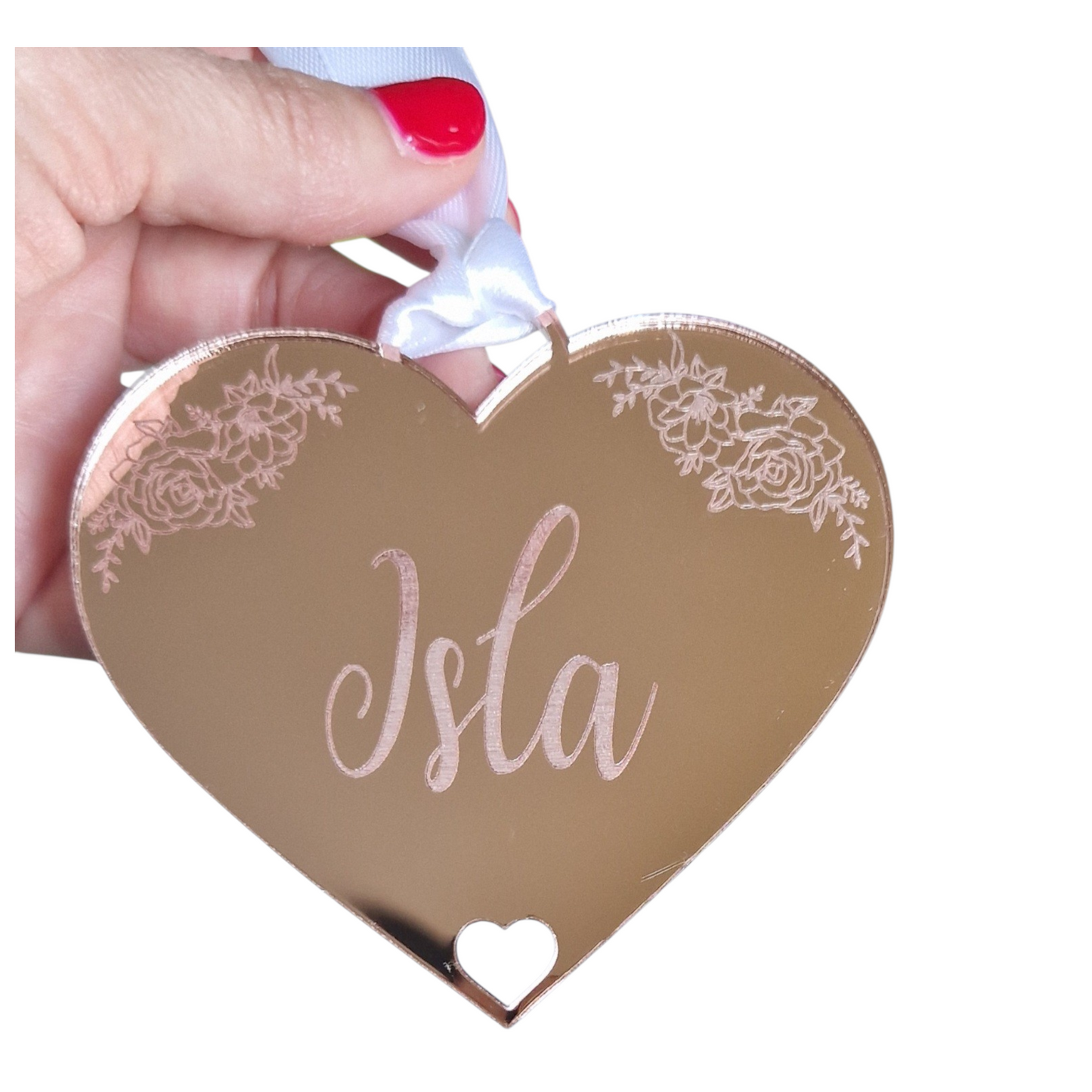 Heart-shaped gift tag in rose gold with 'Isla' on it, held by a hand