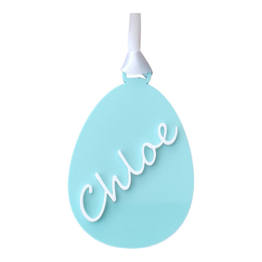 An egg shape in the colour Green Spearmint with the name Chloe going from the bottom to the top on an angle in white. With a white ribbon for hanging