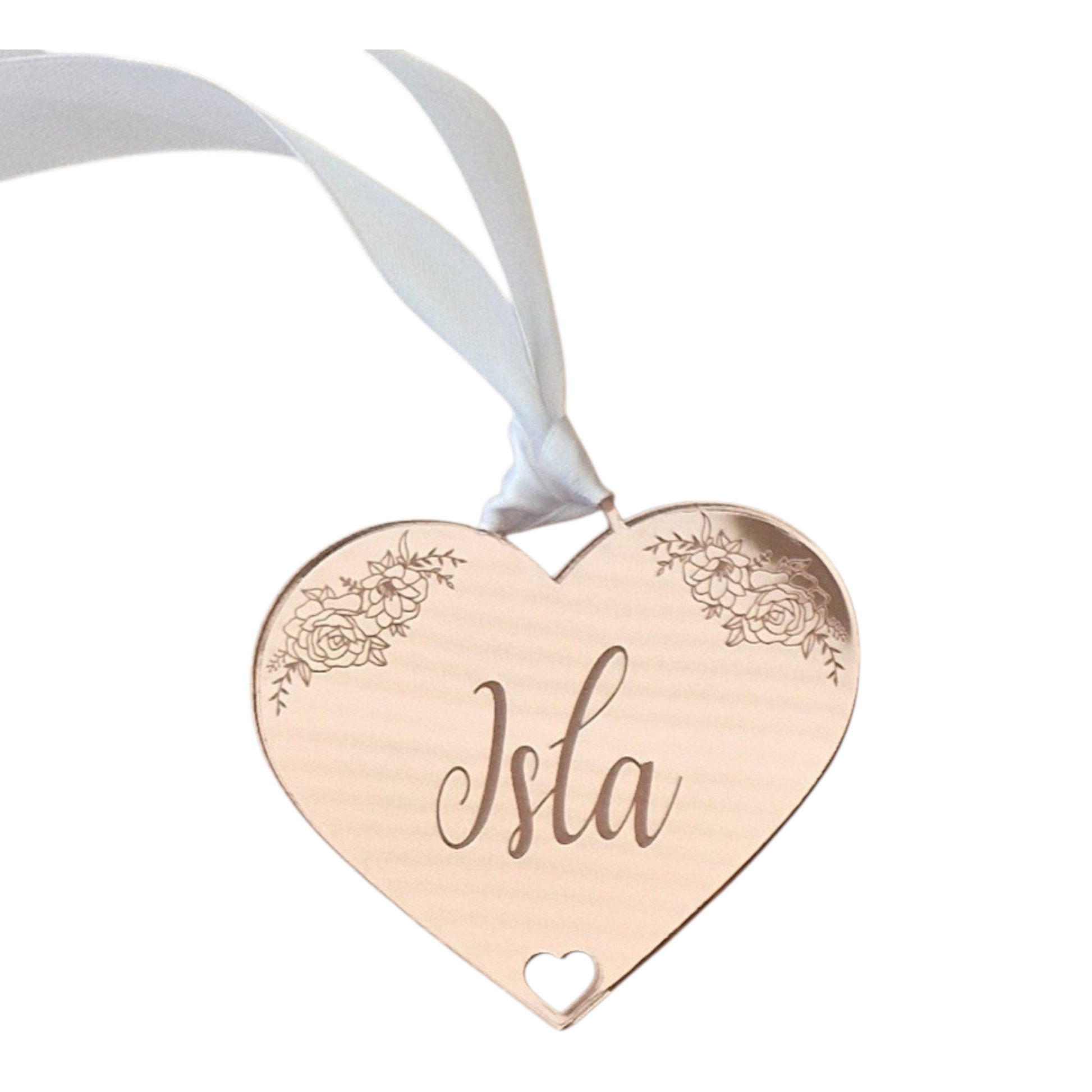 Heart-shaped acrylic gift tag in rose gold, with 'Isla' engraved, hanging on a white ribbon against a white background.