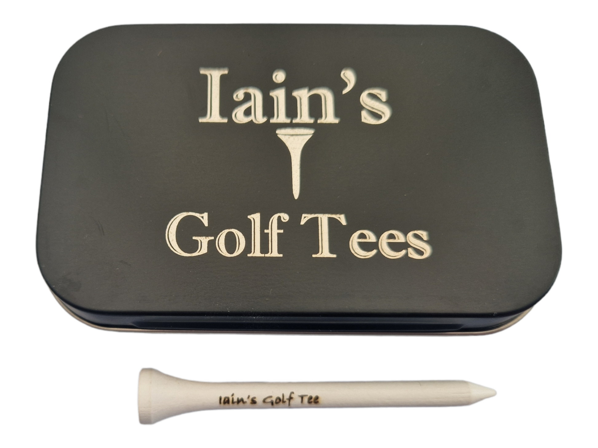 A Black tin with the text "Iain's Golf Tees" and the image of a golf tee laser engraved into it. A 70mm white golf tee laser engraved with the text "Iain's Golf Tee"