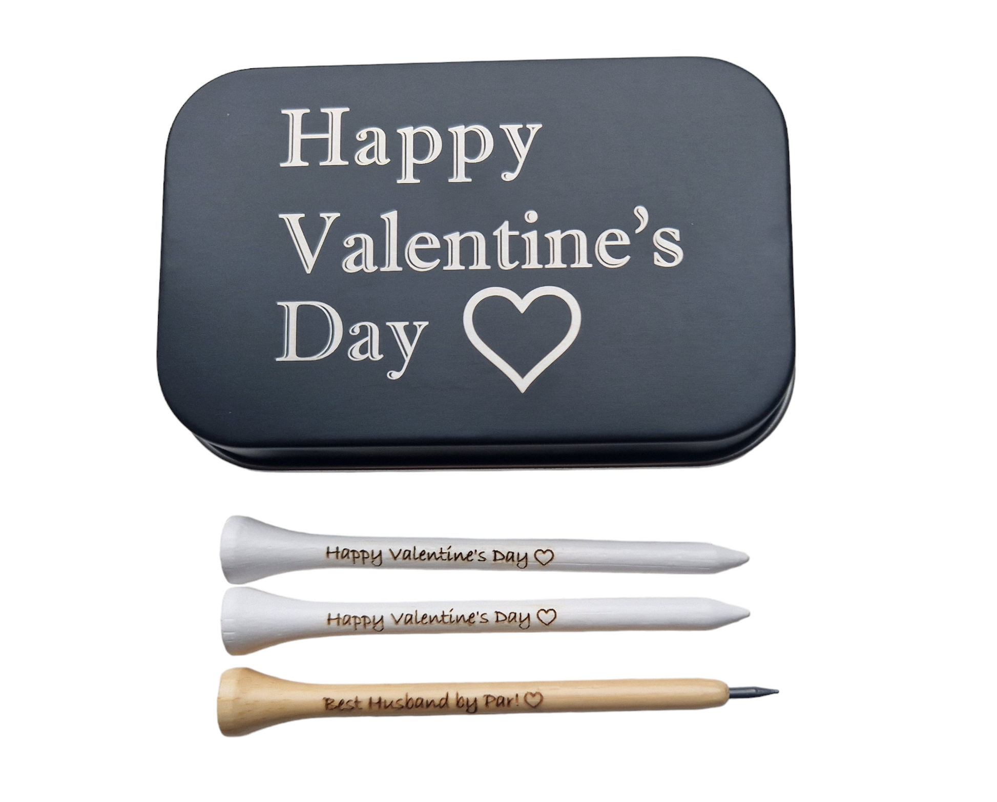 2x83mm white golf tees with the text "Happy Valentine's Day" and an outline of a heart laser engraved into them. 1 x novelty golf tee pencil with the text "Happy Valentine's Day" and an outline of a heart laser engraved into it. 
1 x black metal tin with "Happy Valentine's Day" and an outline of a heart laser engraved into it. 