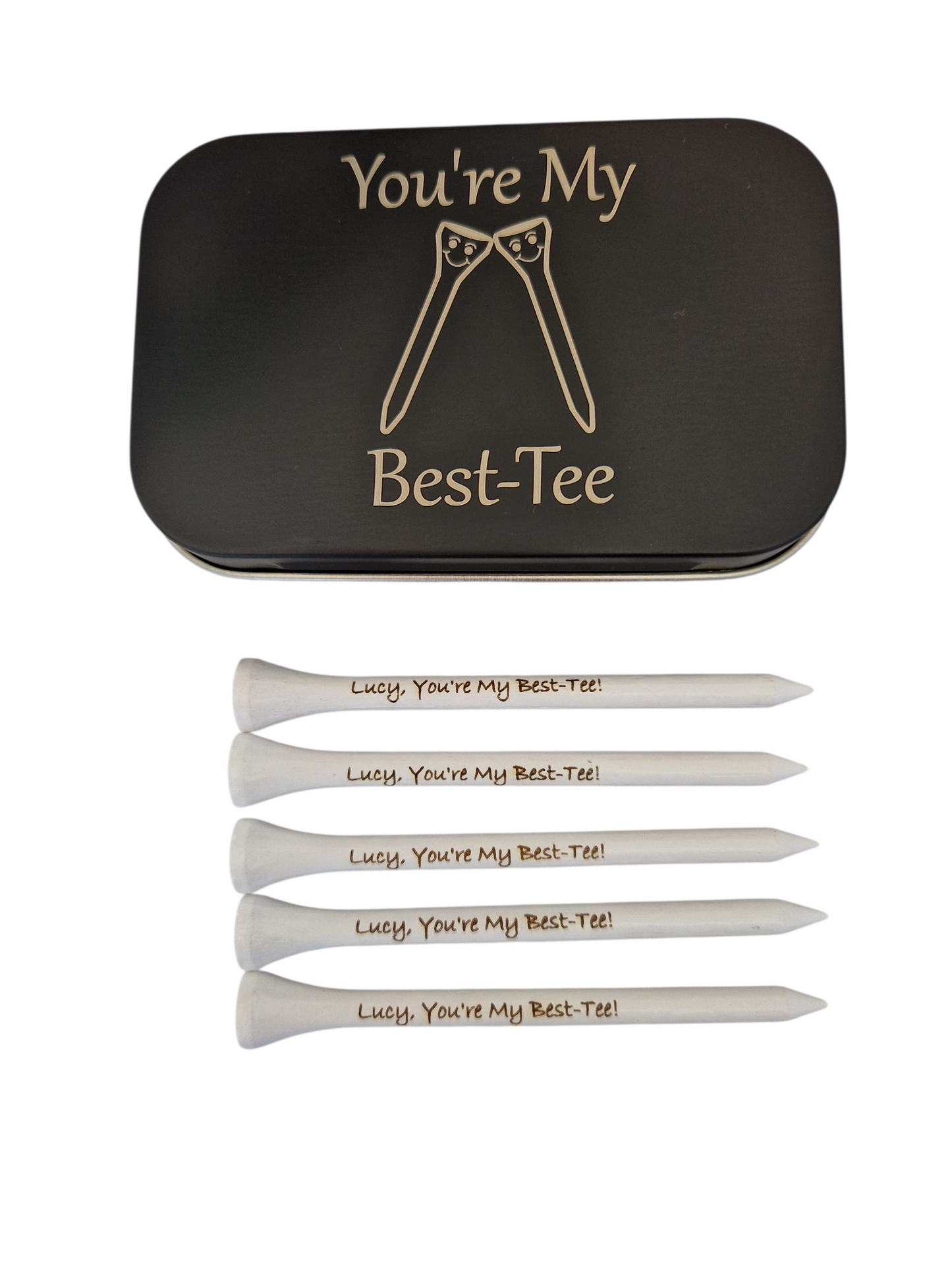 Black metal tin with the text "You're My Best-Tee" and the image of 2 golf tees touching heads. There are smiling faces on the golf tees.
Plus 5 white golf tees with the text "Lucy, You're My Best-Tee!" laser engraved into them