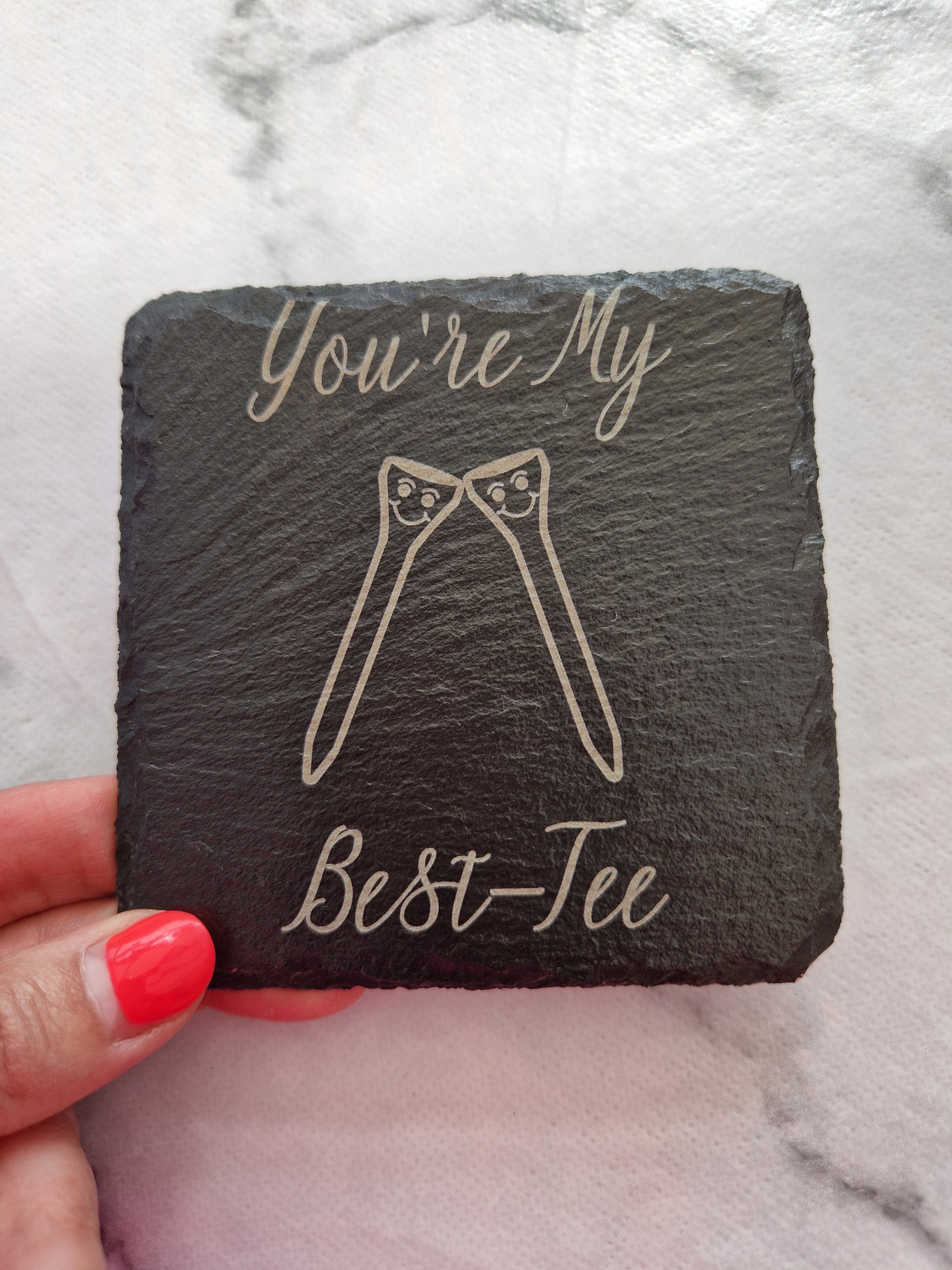 A hand holding a "You're My Best-Tee" laser engraved slate coaster