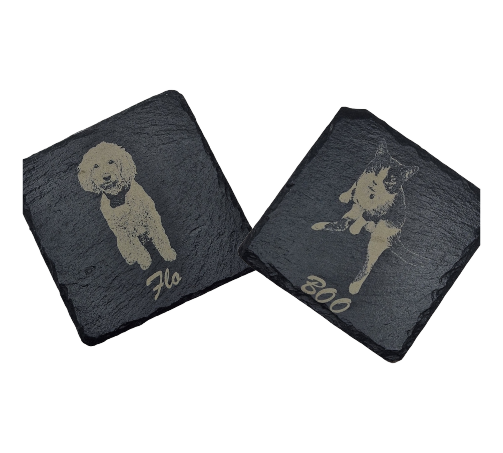 Two slate coasters - lefthand coaster features the image of a dog laser engraved on to it, with the text "Flo" written at the bottom in cursive text. The right hand coaster features the image of a cat laser engraved on to it, with the text "Boo" written in cursive text at the bottom