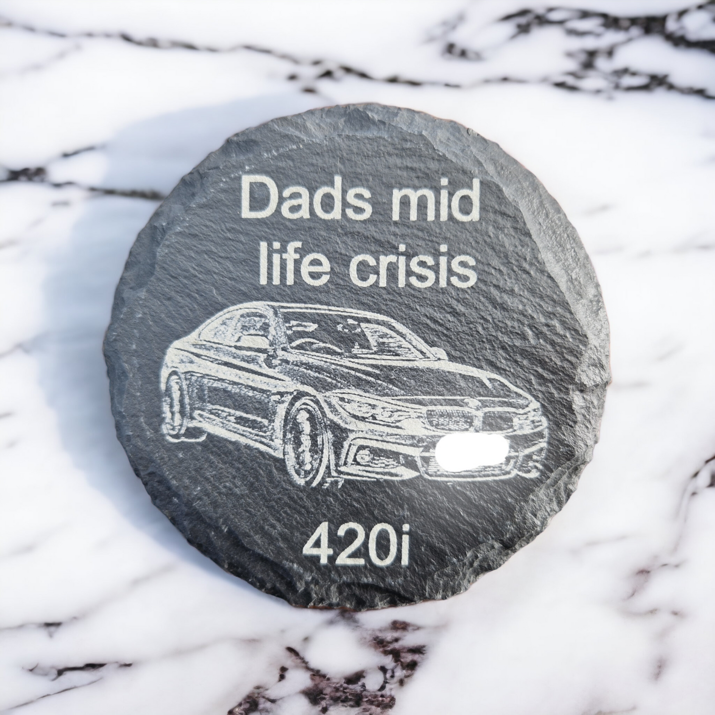 Round slate coaster with the text "Dads mid life crisis" at the top, "420i" at the bottom and the image of a BMW 420i laser engraved in the middle of the coaster