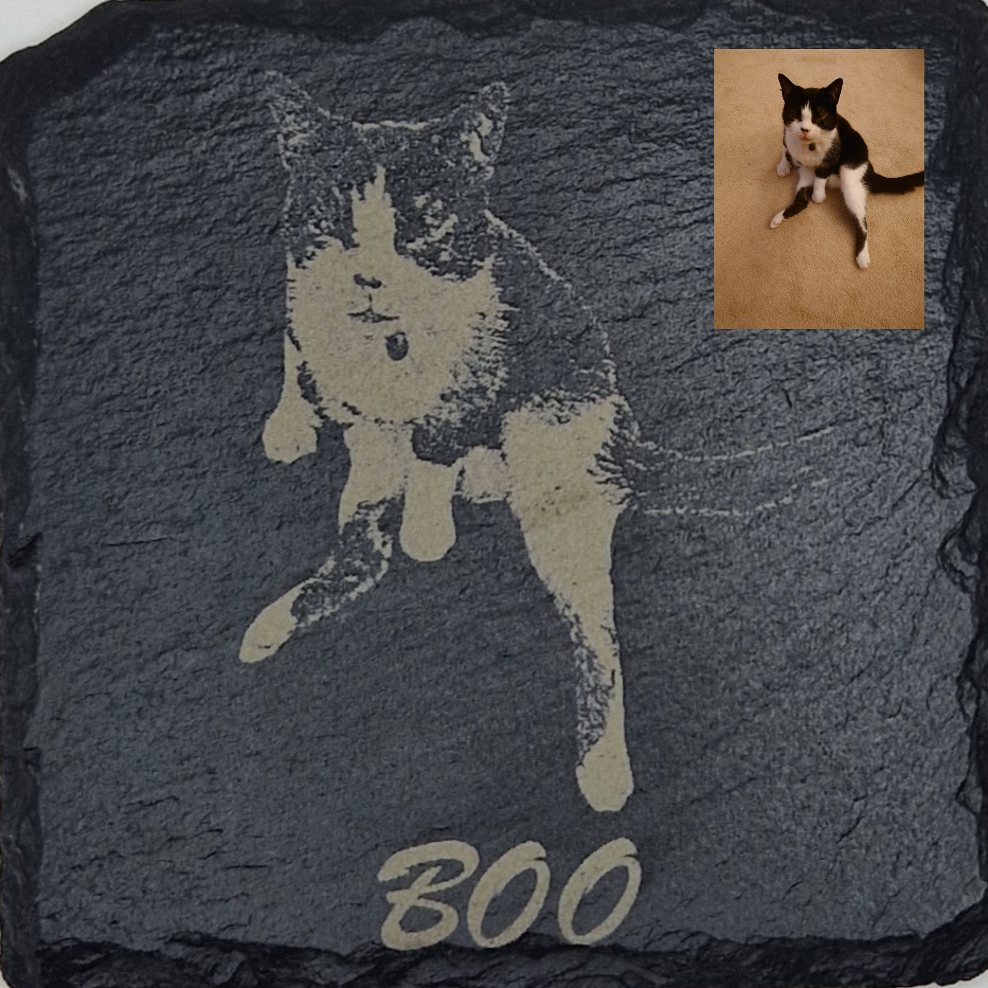 Slate coaster featuring the image of a cat laser engraved into it, with the text "Boo" written at the bottom in cursive text. In the top right corner there is a picture of the original image that was used, showing that the background has been removed. 